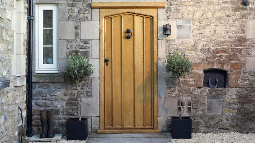 External oak wood door on an old stone building.