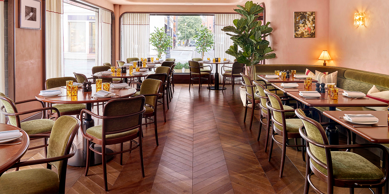 Rich toned parquet flooring in a restaurant with terracotta walls and green chairs