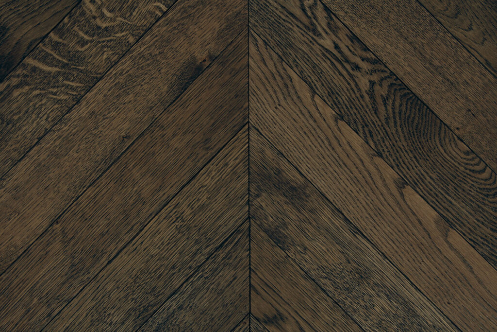 Dark oak chevron flooring with visible grain and colour variation.