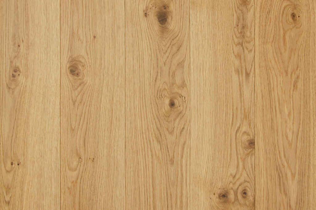 Broadleaf oak plank floor with elegance grade with visible grain and midsize knots.