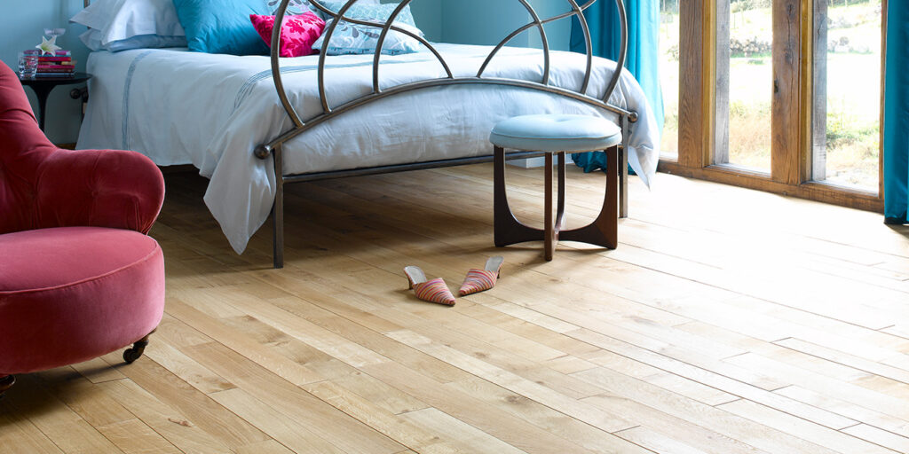 Natural oak plank Broadleaf flooring laid in a bedroom.