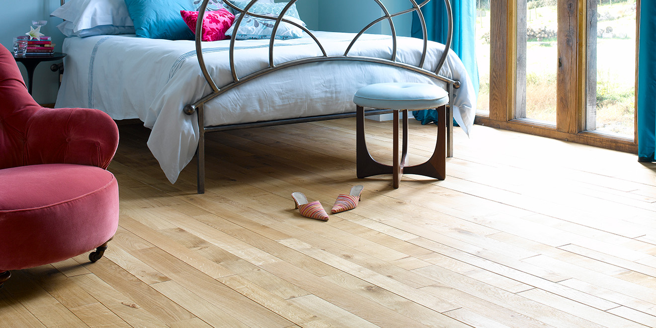 Natural oak plank Broadleaf flooring laid in a bedroom.